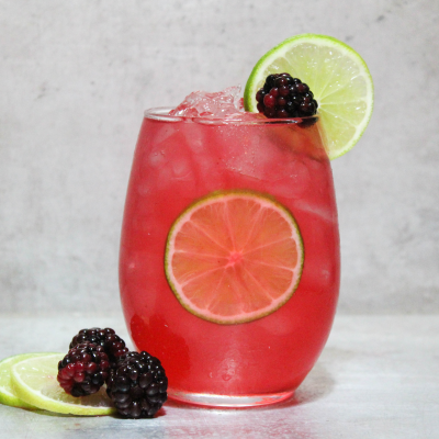 Cocktail garniert mit Brombeeren und Gurkenscheiben